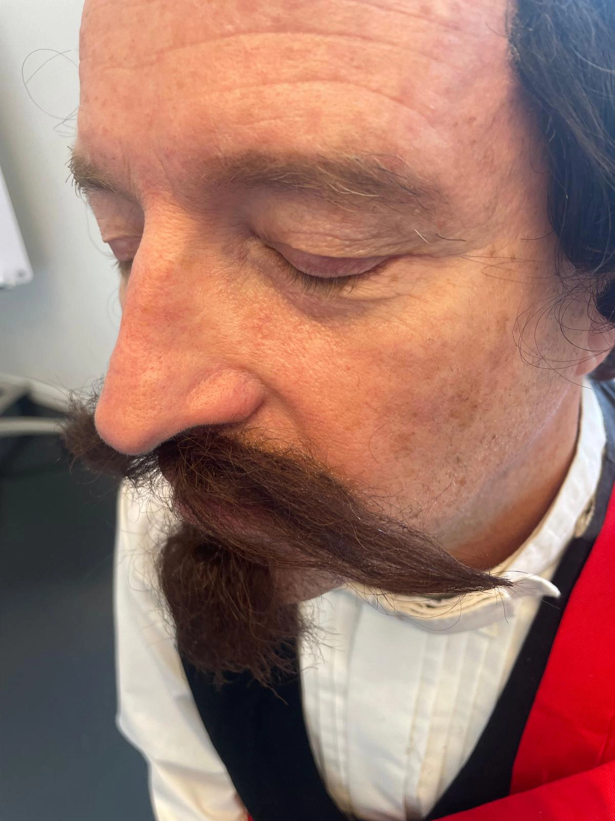 Gros plan sur la pose de la moustache et du bouc en tulle pour le Duc de Morny, maquillage cinéma réalisé par Justine Fiorito.
